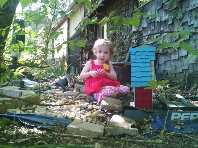 Little Juliet plays with the fairy house